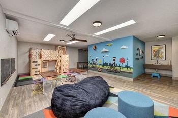 a room with a couch and chairs and a mural on the wall